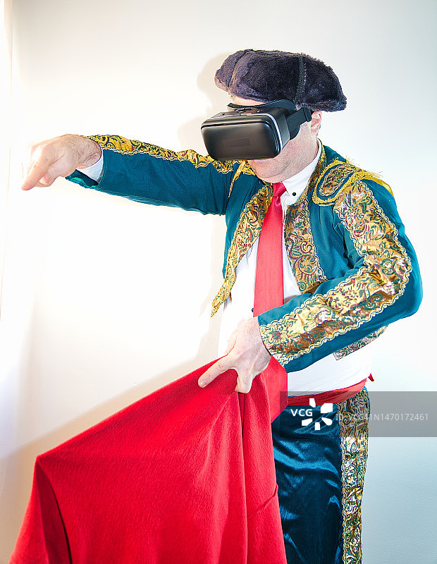 装扮成斗牛士并佩戴VR眼镜的男人图片素材