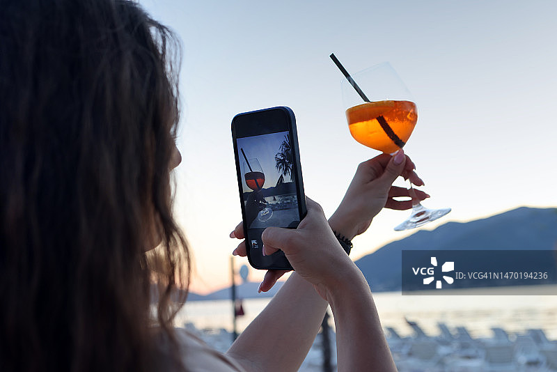 女人拍摄海滩鸡尾酒照片图片素材