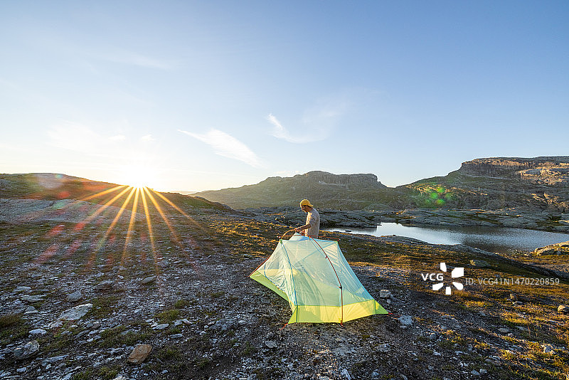 男人在挪威户外搭建帐篷图片素材