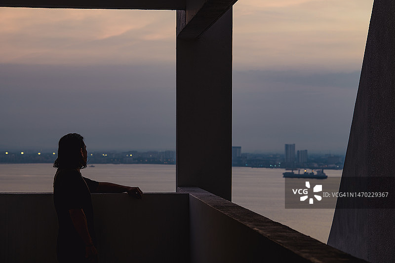 黎明时分站在屋顶上的男人轮廓图片素材