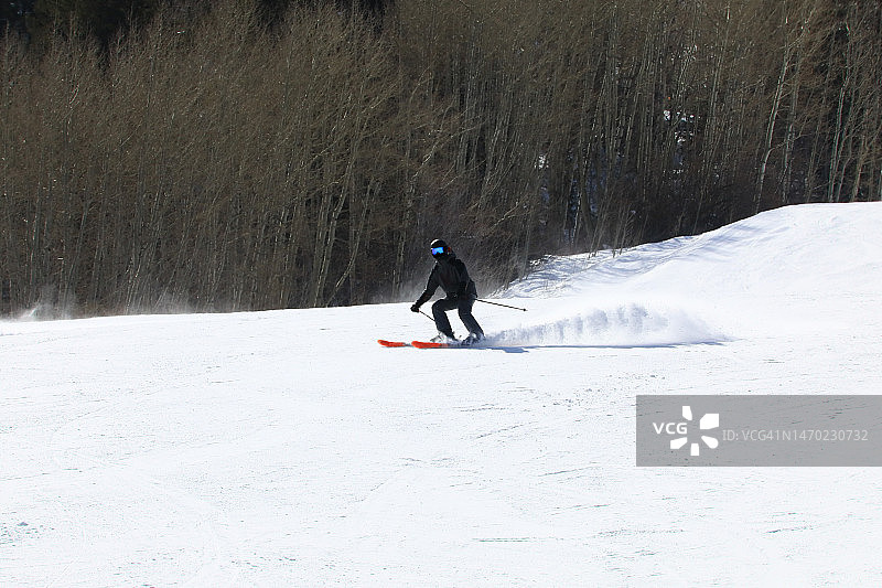 在白雪皑皑的斜坡上速降滑雪图片素材
