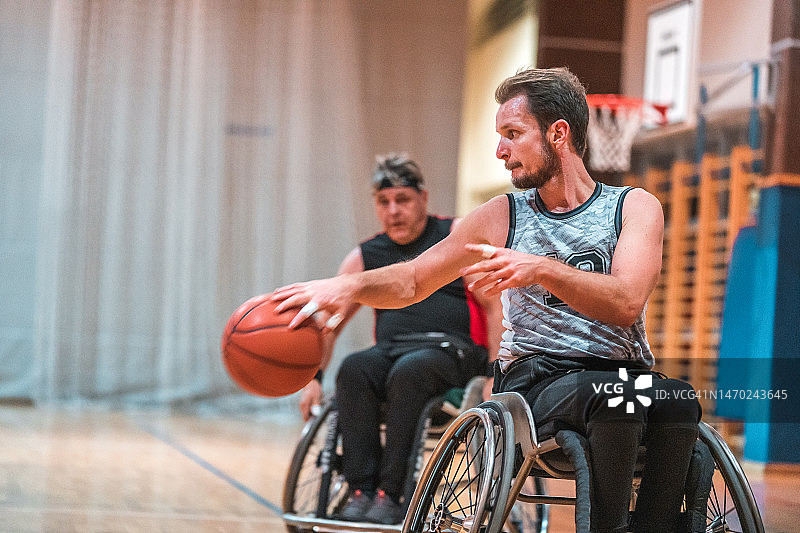 男子轮椅篮球运动员在练习中运球图片素材