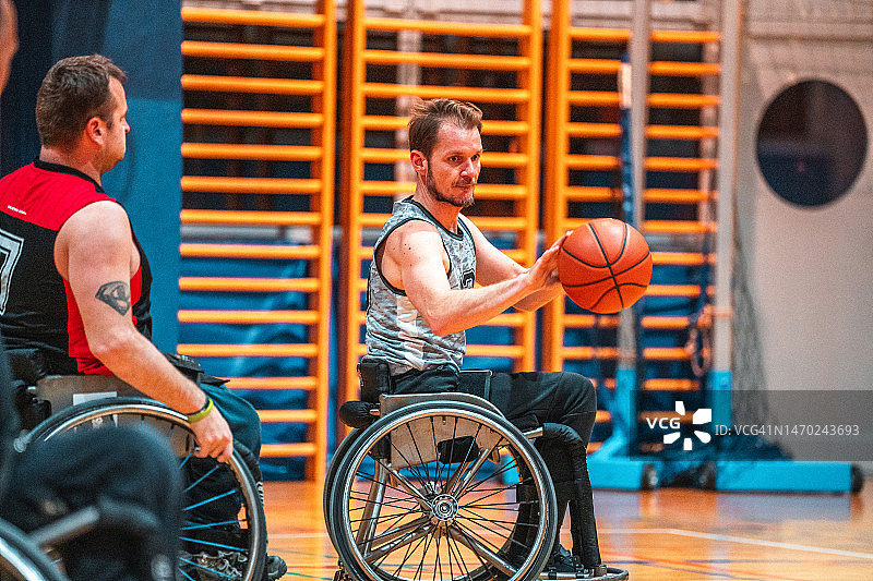 在练习赛中运球的中年男子轮椅篮球队员图片素材