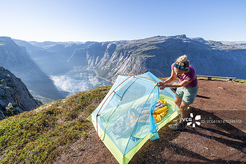 在挪威户外搭帐篷的女人，景色壮观图片素材