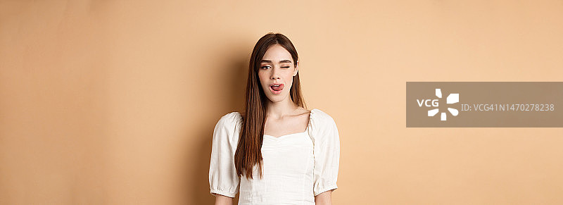 对着镜头吐舌头和眨眼的年轻女人图片素材