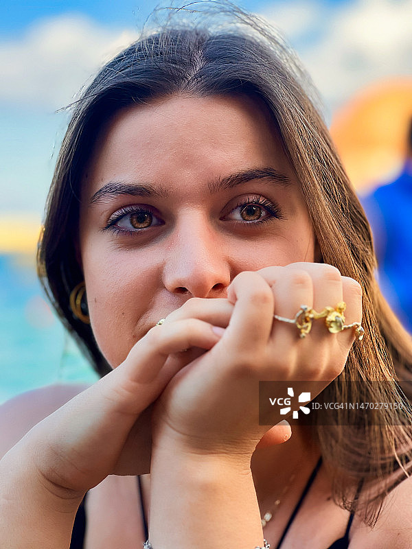 以天空为背景的年轻女人的特写肖像图片素材