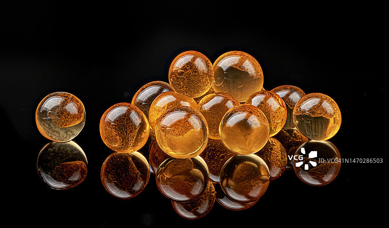 黑色背景上孤立的红色鱼子酱，微距图片素材