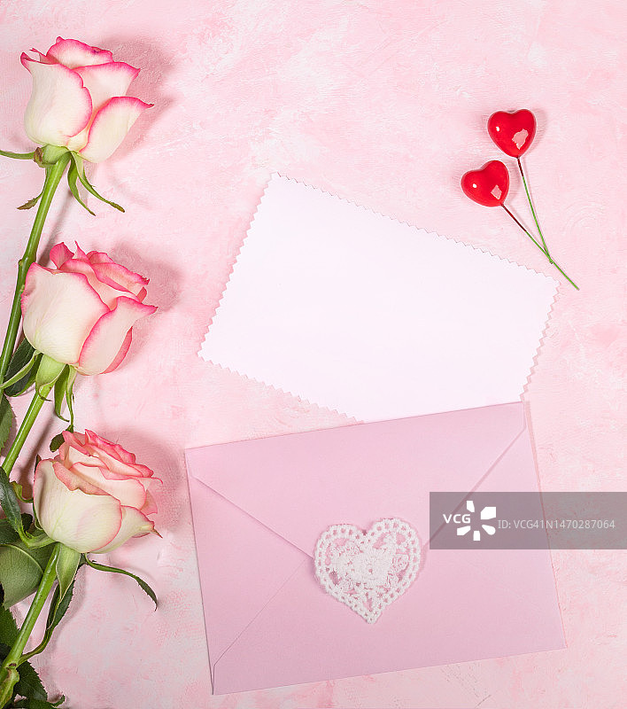 淡粉色玫瑰、信封和爱心的节日平面布置图片素材