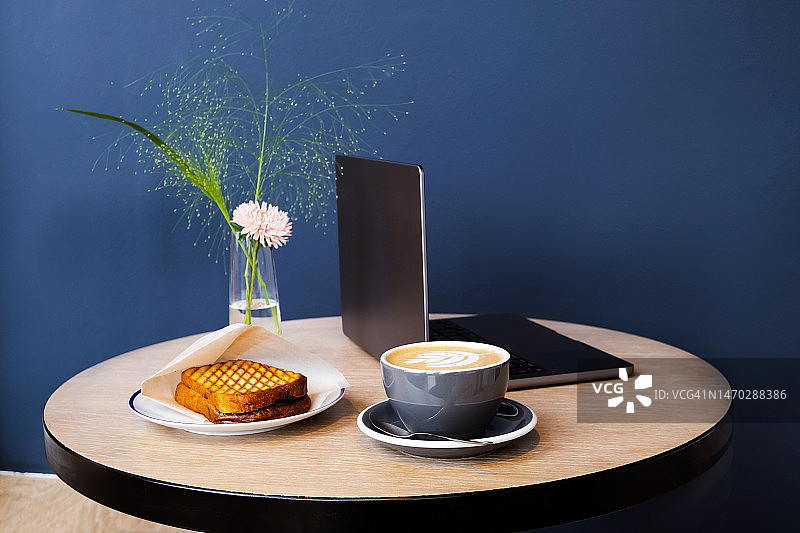 共享办公空间或办公室中的工作场所，一台笔记本电脑，一杯咖啡图片素材