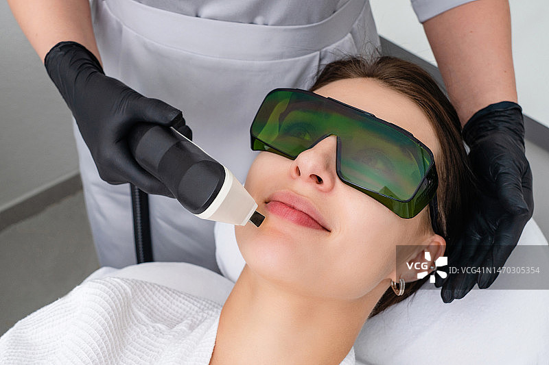 年轻女人在美容诊所接受激光治疗图片素材