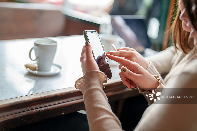 年轻女子使用的智能手机特写图片素材