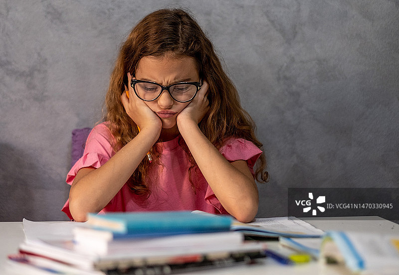 忧心忡忡的女孩在做作业图片素材