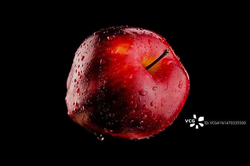 黑色背景下的湿苹果特写图片素材
