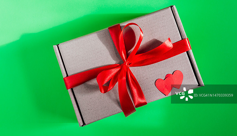 绿色背景上的红色丝带礼盒图片素材