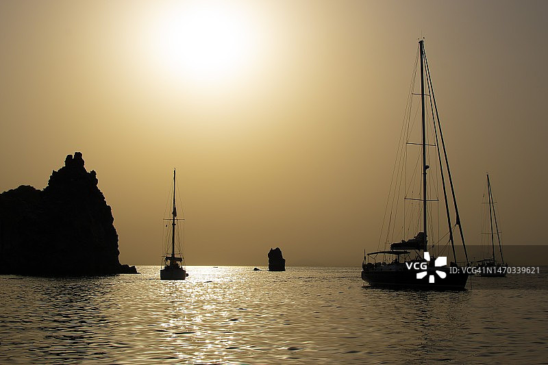 意大利墨西拿利帕里火山维科日落时分晴空下的帆船剪影图片素材