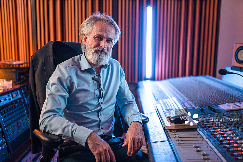 年长的男性作曲家在录音棚里夜间作曲图片素材