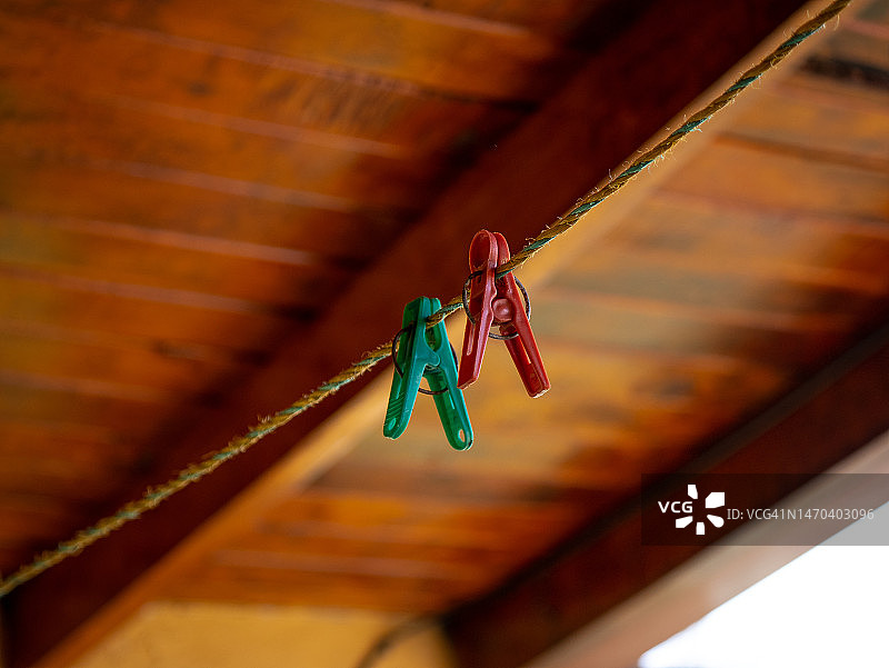 挂在绳子上的洗衣挂钩与木制天花板背景图片素材