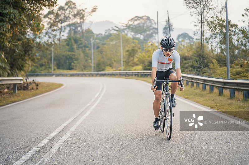 在乡村地区冲刺骑行的中国职业自行车运动员图片素材
