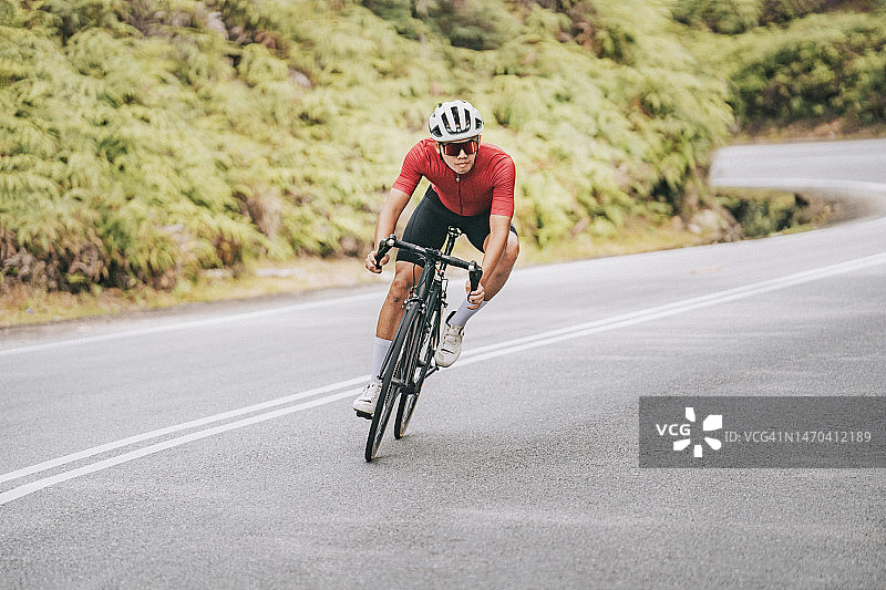 在乡村地区冲刺骑行的中国职业自行车运动员图片素材