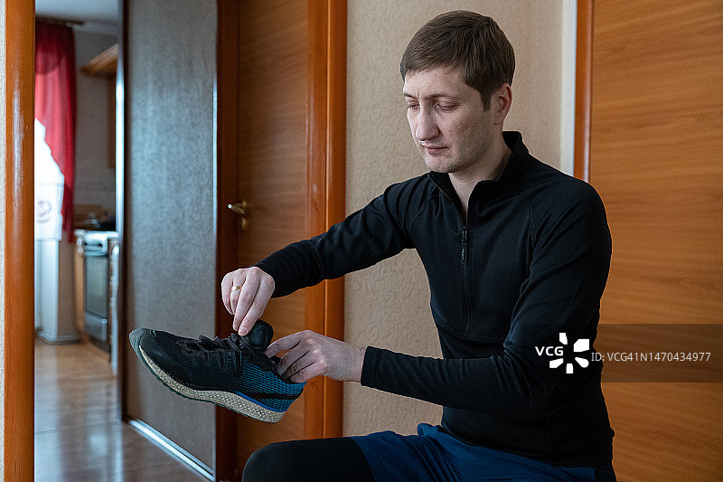 年轻男子早上穿上运动鞋准备慢跑图片素材