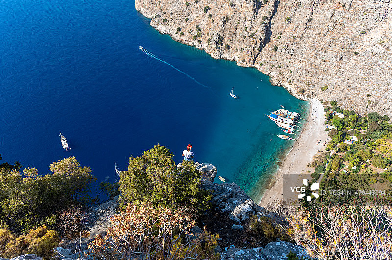 年轻女人在岩石上观看山谷图片素材