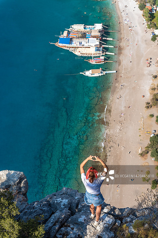 年轻女人在岩石上观看山谷图片素材