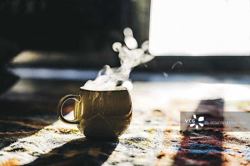 在温暖的摩洛哥地毯上，一杯热气腾腾的茶的舒适居家照图片素材