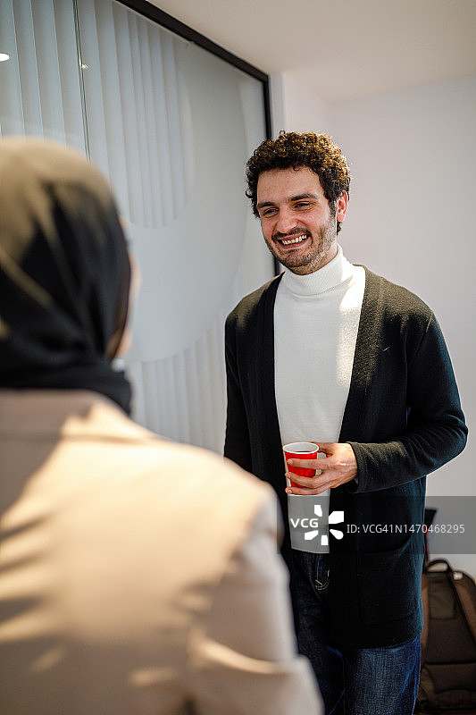 商务伙伴在办公室走廊进行讨论图片素材