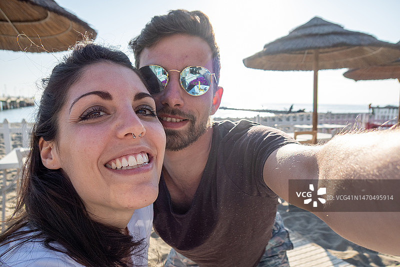 年轻夫妇在托斯卡纳海滩自拍图片素材