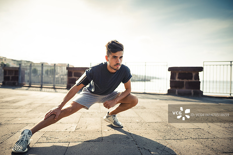 在城市里做伸展运动的男人图片素材
