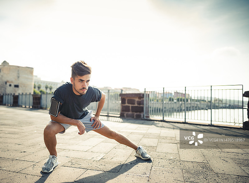 在城市里做伸展运动的男人图片素材