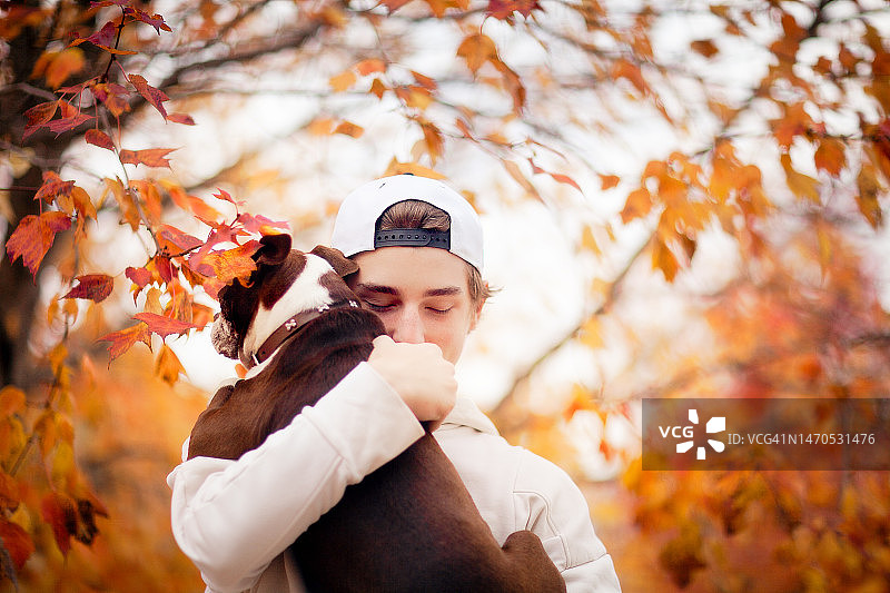 抱着波士顿梗犬的青少年男孩图片素材