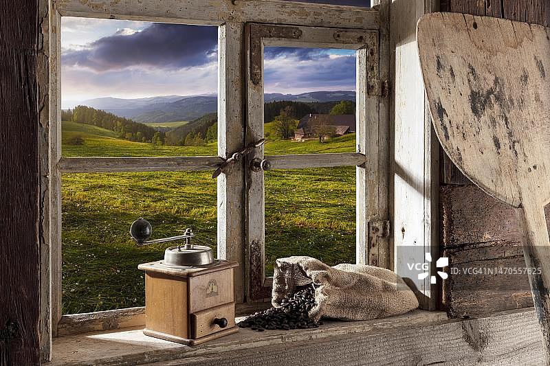 德国乡村客厅，窗台上放着咖啡研磨机和咖啡豆，窗外是风景图片素材