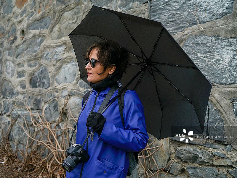 拿着黑色雨伞的时尚女性图片素材