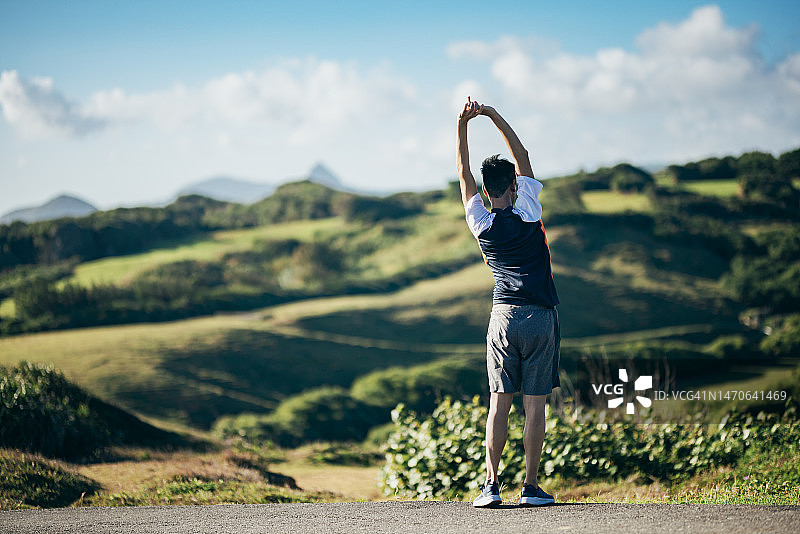 亚洲男子晨跑前在户外做伸展运动图片素材