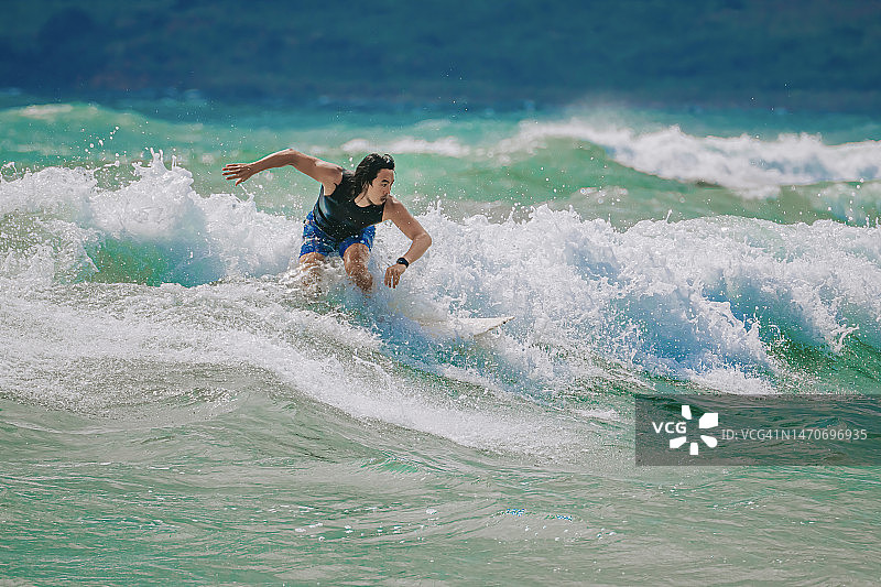 在太平洋冲浪的亚洲男人图片素材