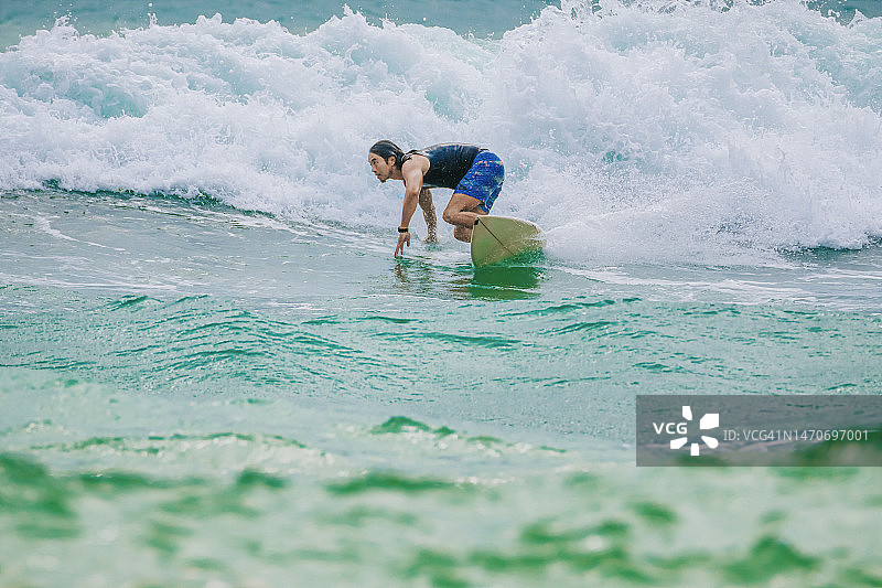 在太平洋冲浪的亚洲男人图片素材