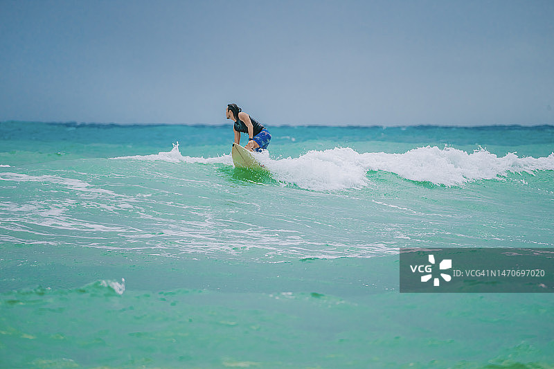在太平洋冲浪的亚洲男人图片素材