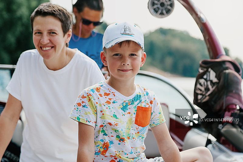 准备好和妈妈一起乘坐快艇的男孩图片素材