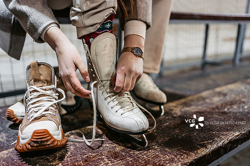 年轻女人系上溜冰鞋的鞋带图片素材