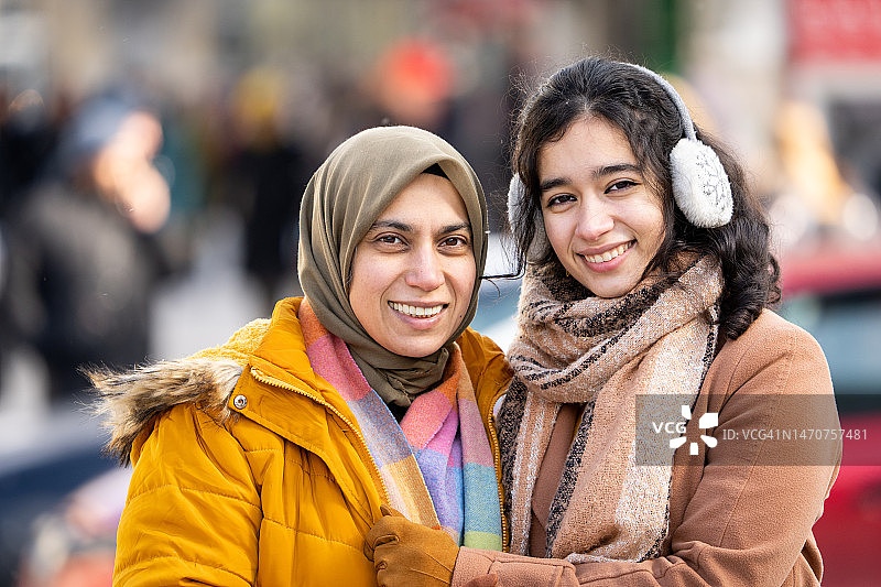 两名女人在拥挤的街道上行走交谈图片素材