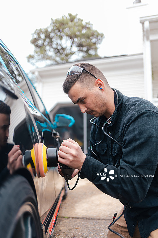 汽车细节：用抛光机抛光黑色汽车去除划痕图片素材