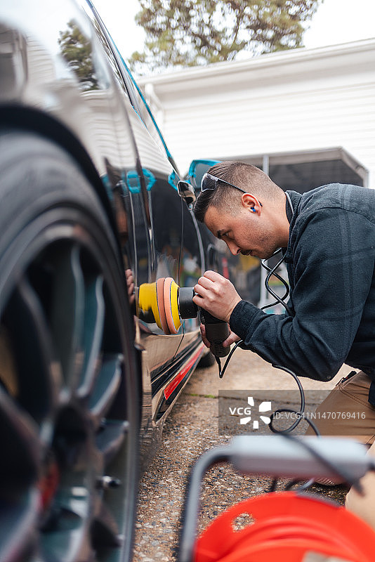 汽车细节：用抛光机抛光黑色汽车去除划痕图片素材
