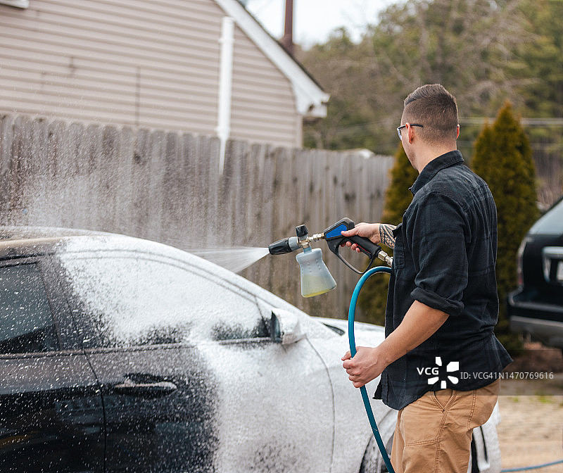汽车细节护理：男子用高压清洗机泡沫洗车图片素材