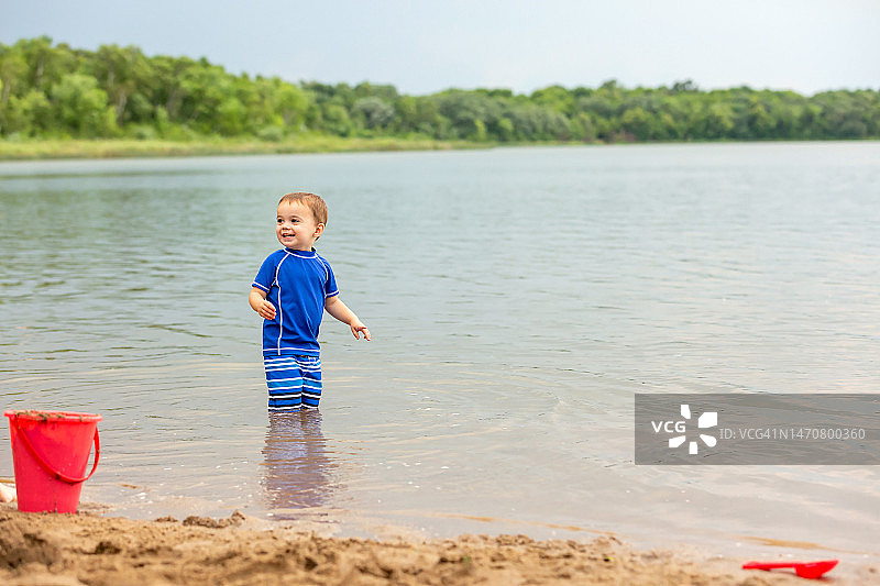 男孩站在海滩的水中图片素材