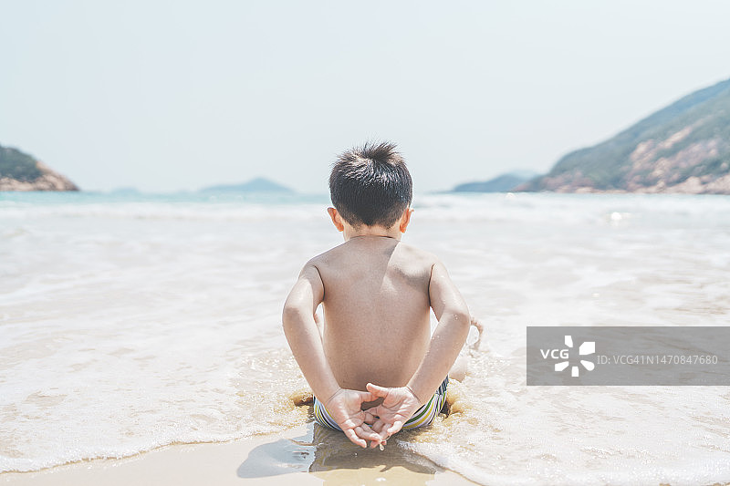 男孩在香港的海滩上玩耍图片素材