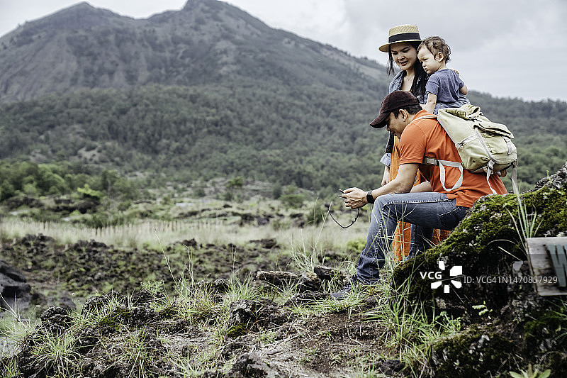 亚洲夫妇抱着婴儿眺望巴图尔火山图片素材