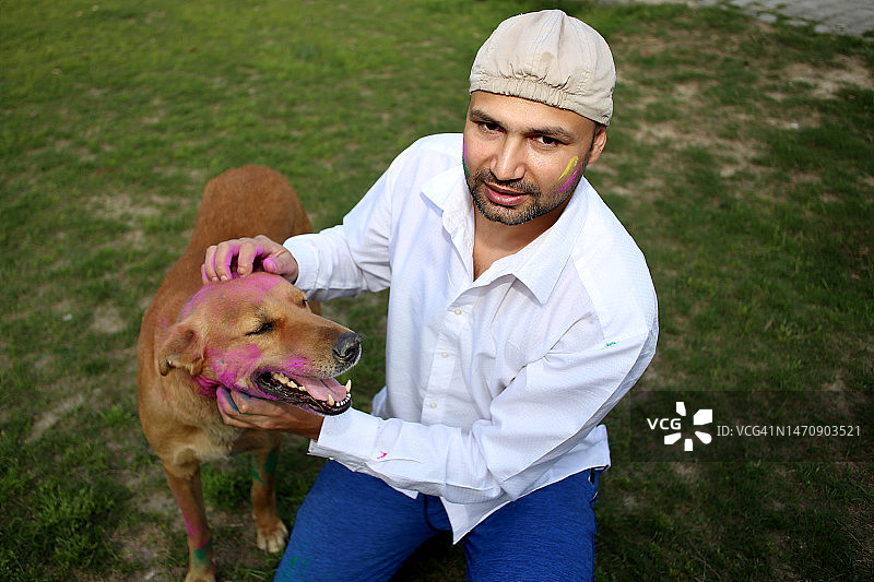 宠物主人和他的狗一起庆祝洒红节图片素材