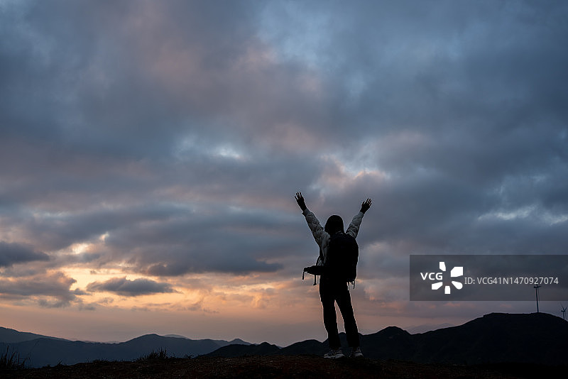 登山者举起双手庆祝成功登顶图片素材