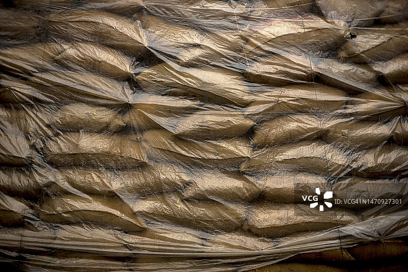 堆叠并用塑料布覆盖的米袋图片素材